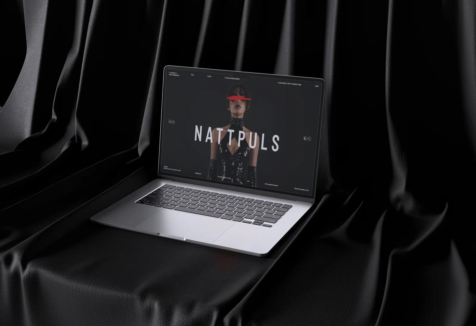 Laptop på svart silke med forsiden til en nettbutikk for mote