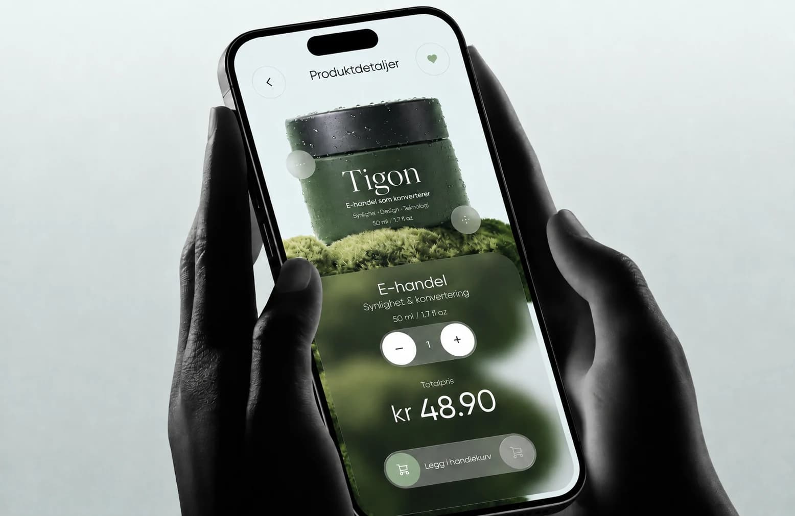 Hender holder en smarttelefon med grønn Tigon-handleapp, produktdetaljer og handlekurv